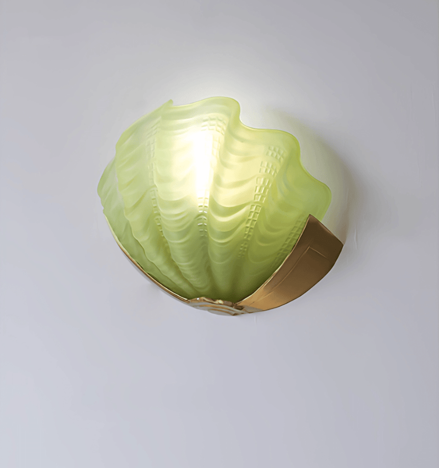 The green frosted glass shade lit on a plain wall, the ridges catching light