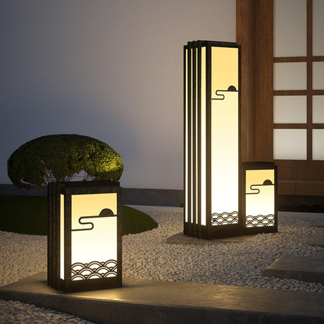 Two sizes lit in a raked gravel garden beside a clipped green mound