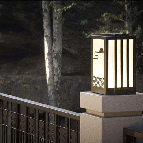 The lantern lit on a pale post cap beside a slatted timber fence