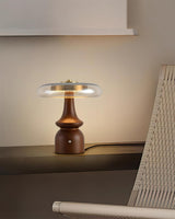 Side table lamp lit beside a woven chair in a dim room