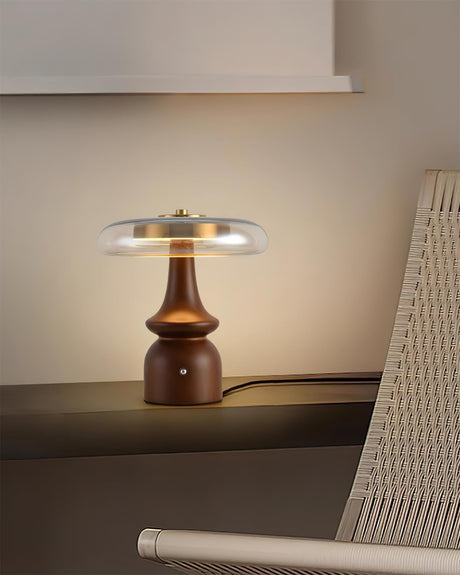 Side table lamp lit beside a woven chair in a dim room