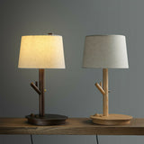 A light wood lamp and a walnut lamp side by side on a wood surface