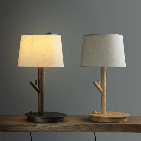 A light wood lamp and a walnut lamp side by side on a wood surface