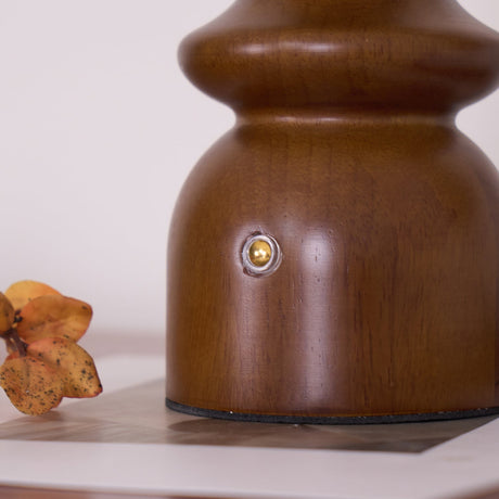 Close view of the color temperature button on the walnut foot