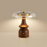 Side table lamp lit against a warm beige ground, seen from the front