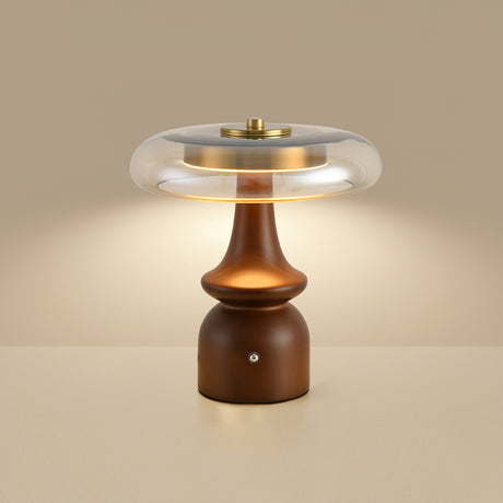 Side table lamp lit against a warm beige ground, seen from the front