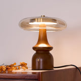 Side table lamp lit on a desk beside dried orange flowers