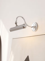 Bright chrome hooded bar lit above a large framed picture on a white wall