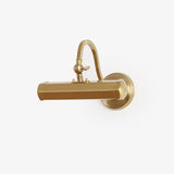 Warm metal hooded bar on a curved arm rising from a round stepped wall plate