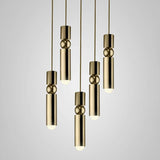 A cluster of slim gold tube pendants lit at different heights