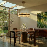 A lit stone ring above a round dining table under a skylight
