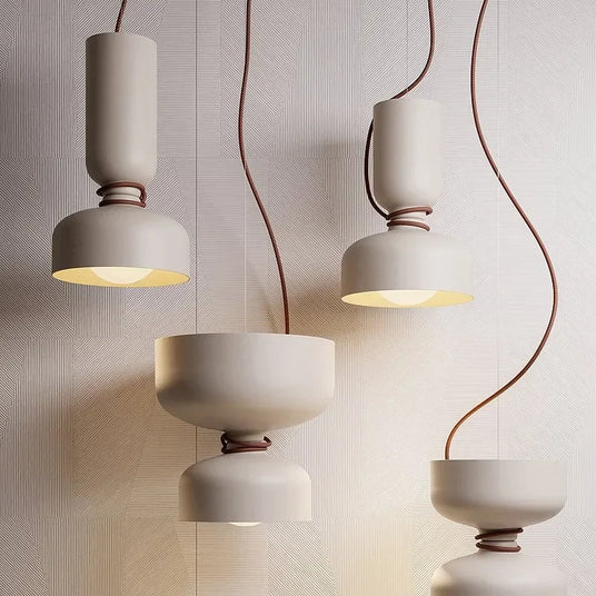 Group of pendants hung at staggered heights on a textured wall