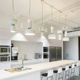 Row of pale pendants above a long kitchen counter