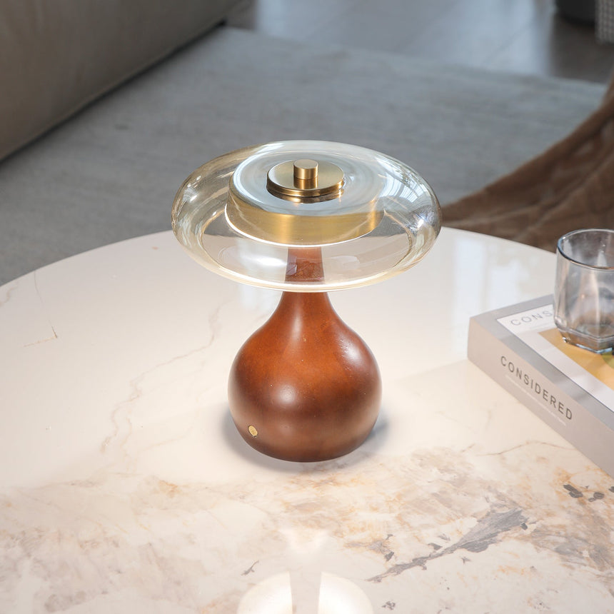 Close view of the lit amber glass ring and the brass finial