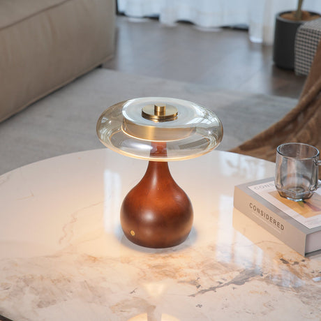 Small table lamp lit on a marble table beside a stack of books