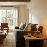 Small table lamp lit on a low table in front of a sofa