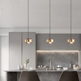 Three brass banded glass pendants in a row above a pale kitchen counter