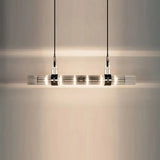 The lit row of smoked glass tubes seen close against a pale wall