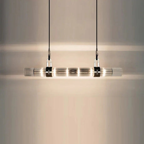 The lit row of smoked glass tubes seen close against a pale wall