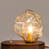 Close view of the amber glass ice form lit on the wood plinth