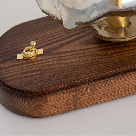 Close view of the dark wood plinth and the brass toggle switch