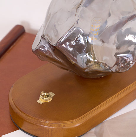 Close view of the smoke gray glass resting on the wood plinth