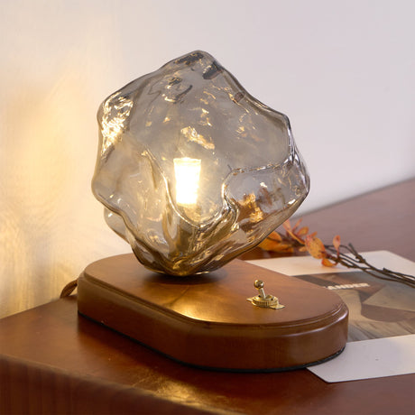 Smoke gray glass ice form lit close, the facets catching light