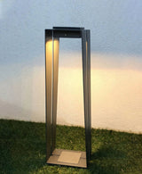 The tall size lit on grass in front of a pale rendered garden wall