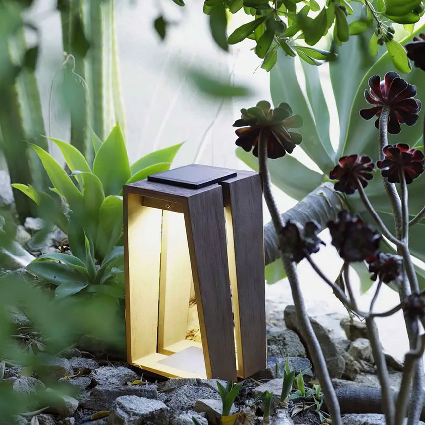 The light lit among planting and pale stones in a garden at dusk
