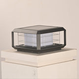The lantern unlit on a white pillar cap seen from a low garden angle