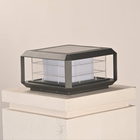 The lantern unlit on a white pillar cap seen from a low garden angle