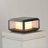 The lantern lit warm on a pale pillar with the grid picked out dark