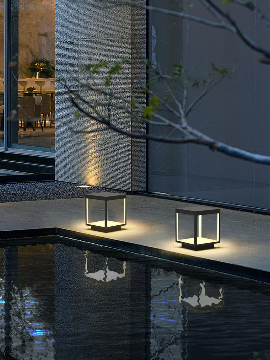 Two frames lit on a pool edge, their reflection held in still water