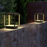 The frame glowing on a stone garden wall with a dark hedge behind