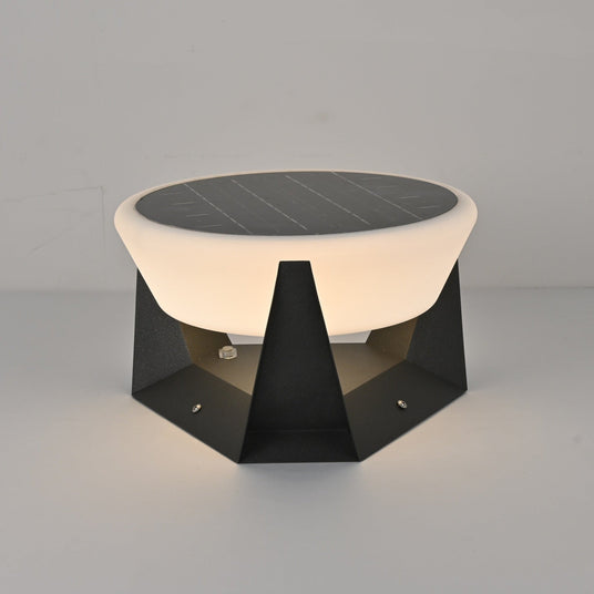 Warm light escaping down between the points of the base onto garden paving
