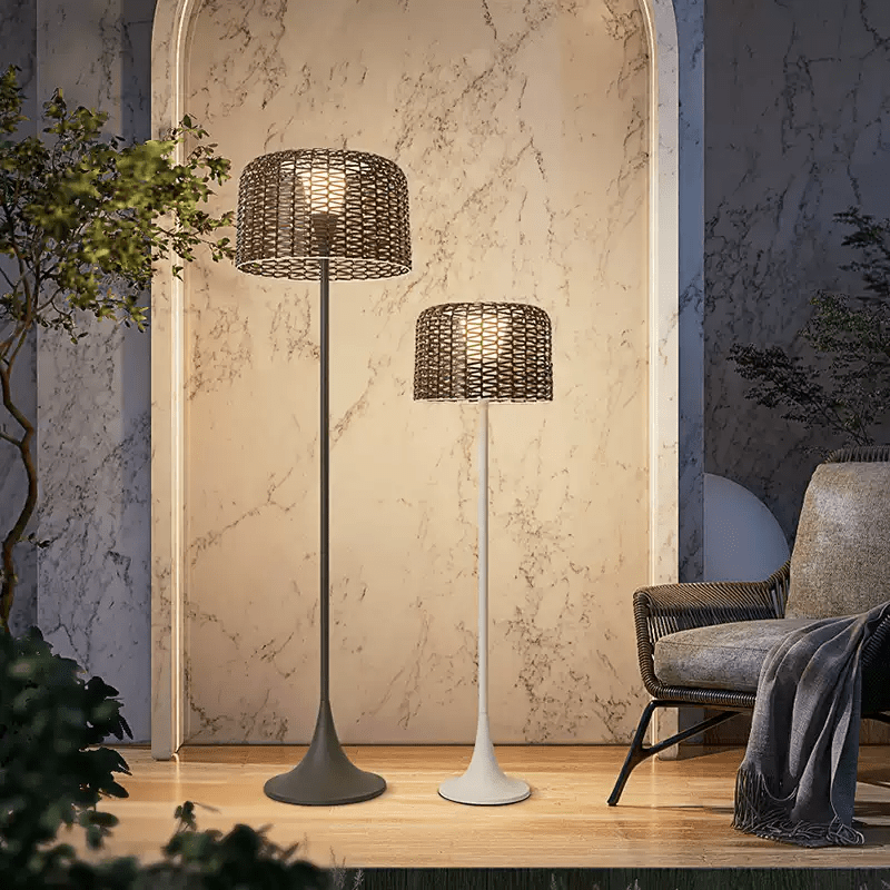 Two sizes lit against a pale marble wall beside an armchair and a throw