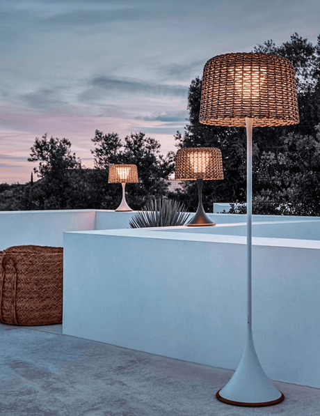 Two lit on a roof terrace at dusk above a low rendered parapet wall