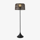 Tall slim floor lamp with a woven drum shade on a trumpet base