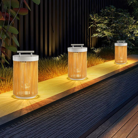 Three lit along a deck edge beside dark planting and a screen
