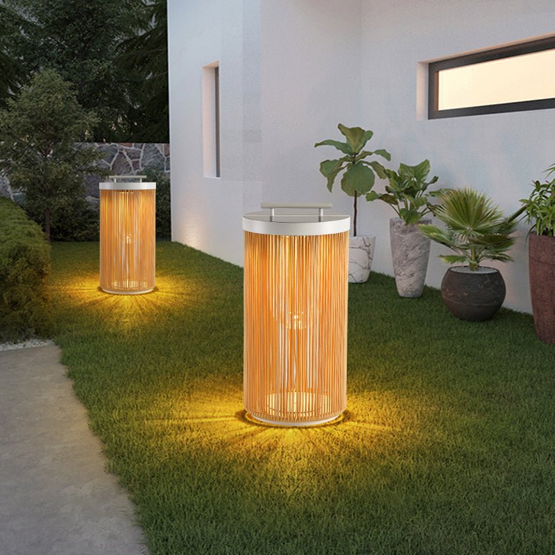 Two lit on grass beside a white render wall and potted planting