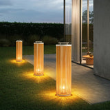 Three sizes lit on a lawn beside a paved walk and a lit house