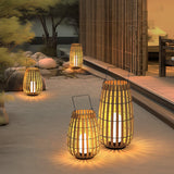 Lanterns lit in a courtyard beside a bamboo screen and pale stones