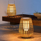 Two lanterns lit on a timber bench on a terrace at the end of the day