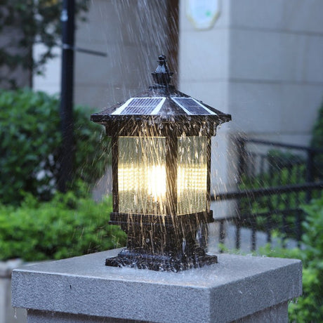 Water running off the lit lantern on a pillar in heavy evening rain