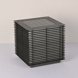 The solar panel set flush into the flat top face of the slatted cube