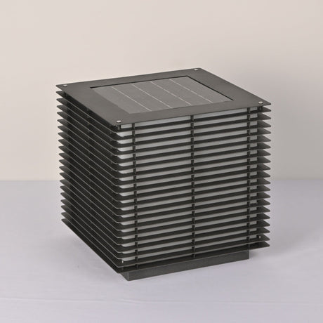 The solar panel set flush into the flat top face of the slatted cube