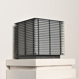 The cube on a stepped stone cap seen level with the slatted sides