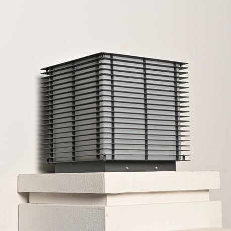 The cube on a stepped stone cap seen level with the slatted sides