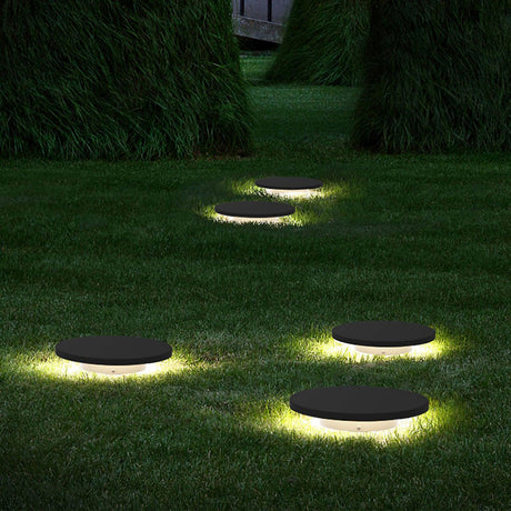 Three lit across a mown lawn with a clipped hedge behind them