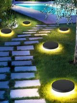 Several lit beside stepping stones leading past a lit swimming pool